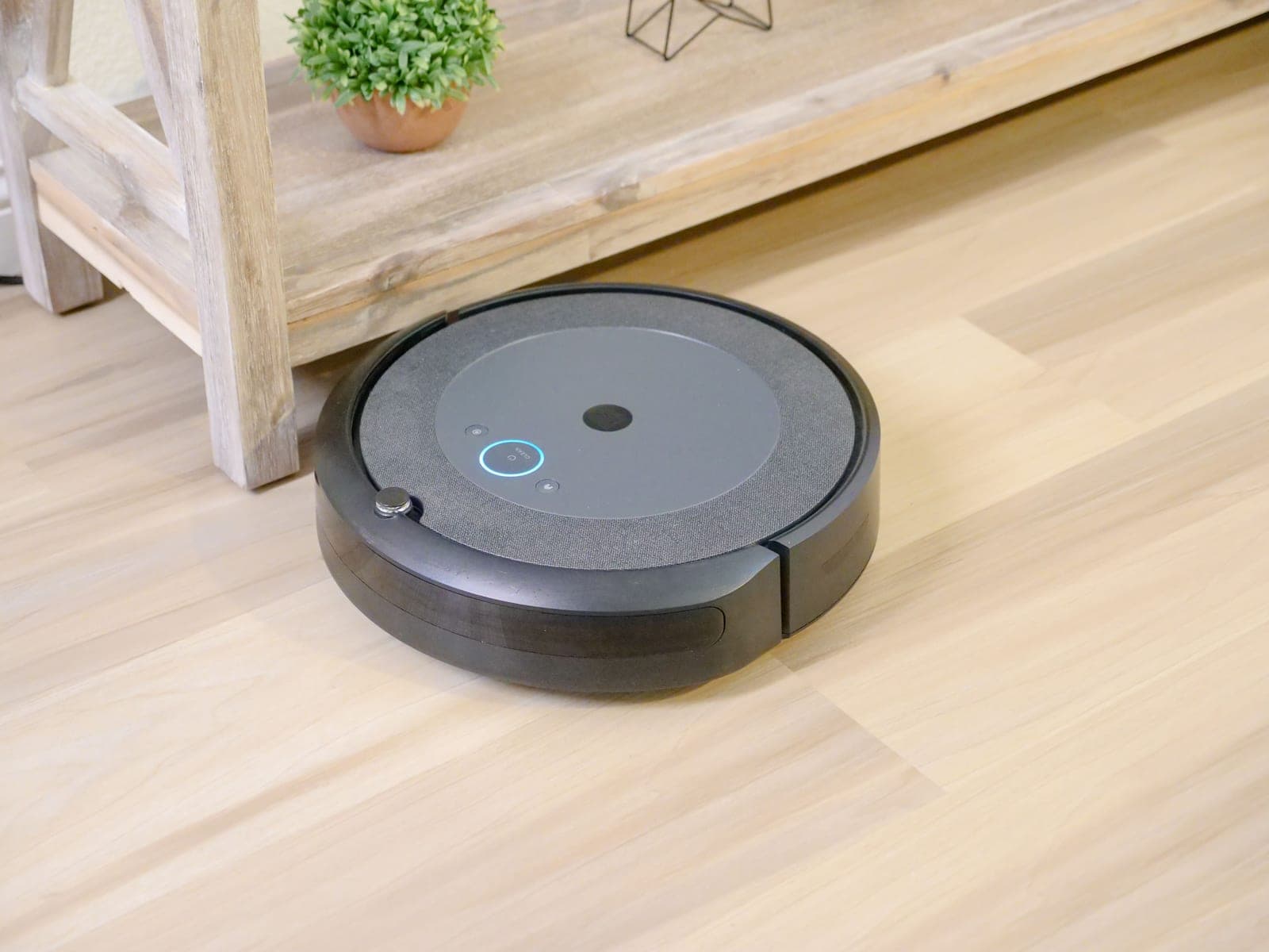 A robot vacuum cleaning a hardwood floor in a lived-in room