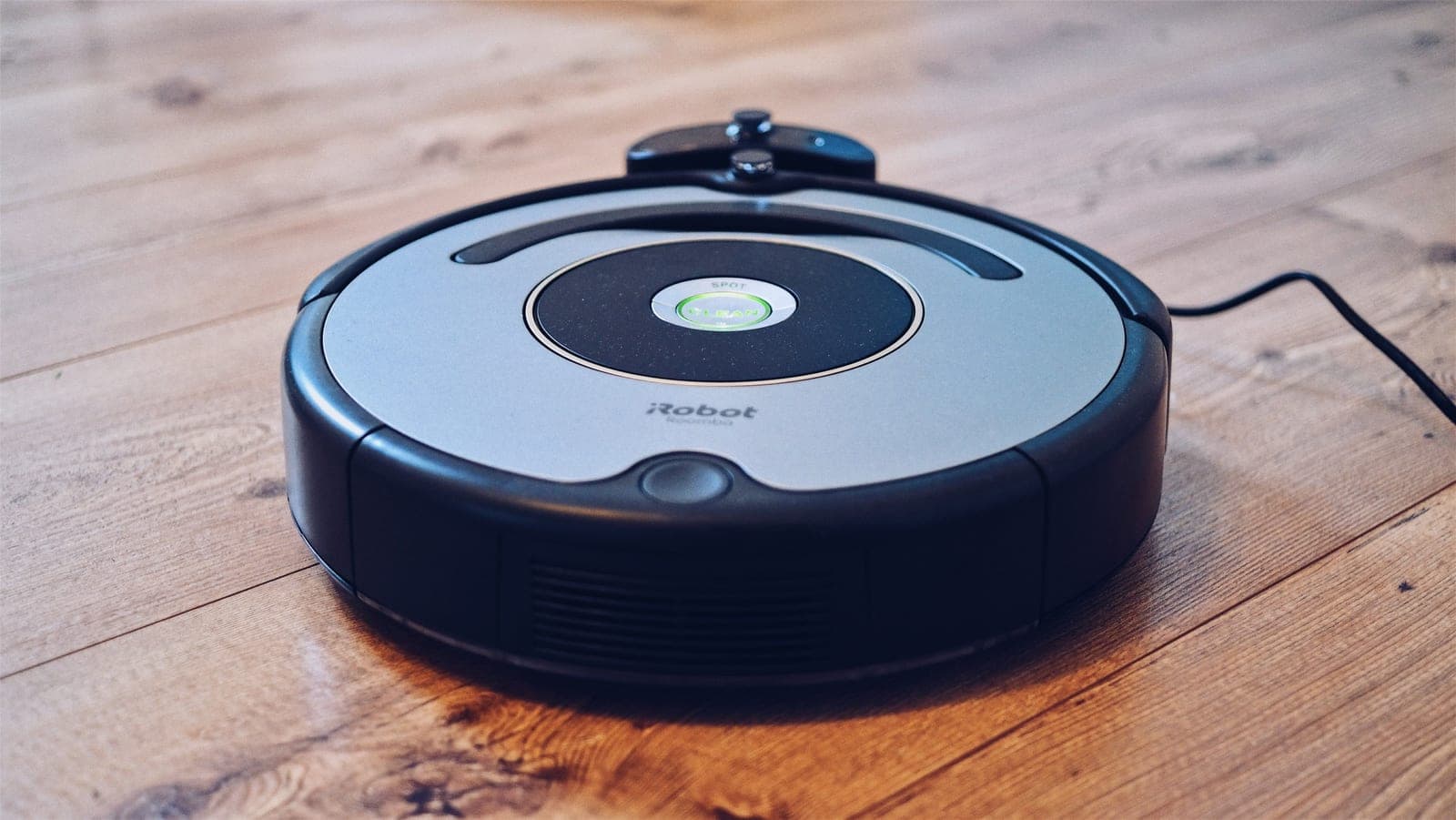 A robot vacuum on a wooden floor